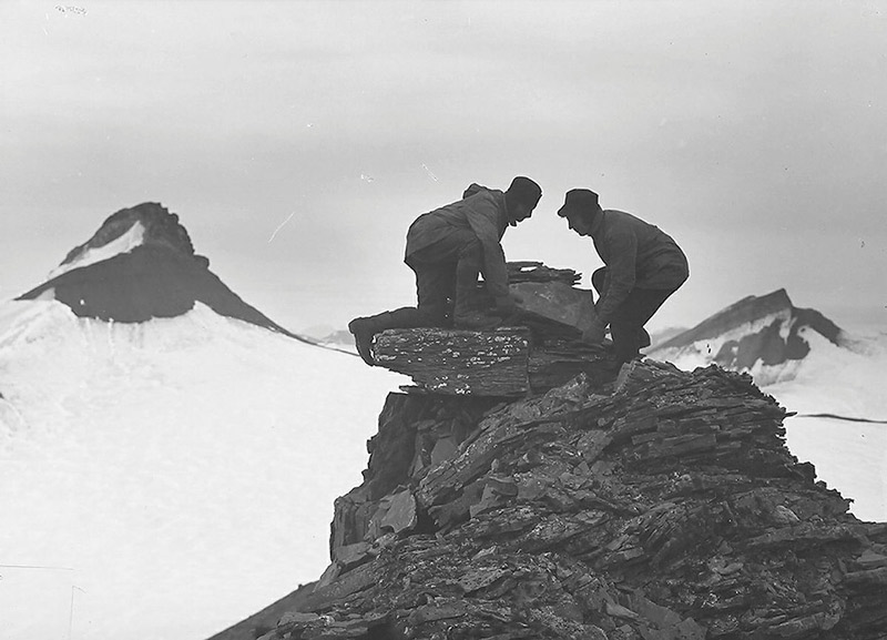 to menn bygger varde på snedekket fjell