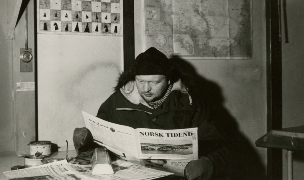 Mann med tjukk jakke leser avisa