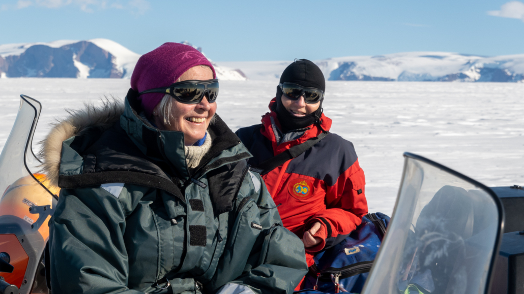 To damer med solbriller med snø bak