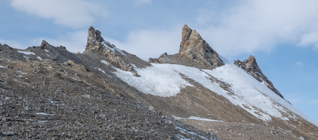 Et fjellområde der tre tydelige topper stikker opp