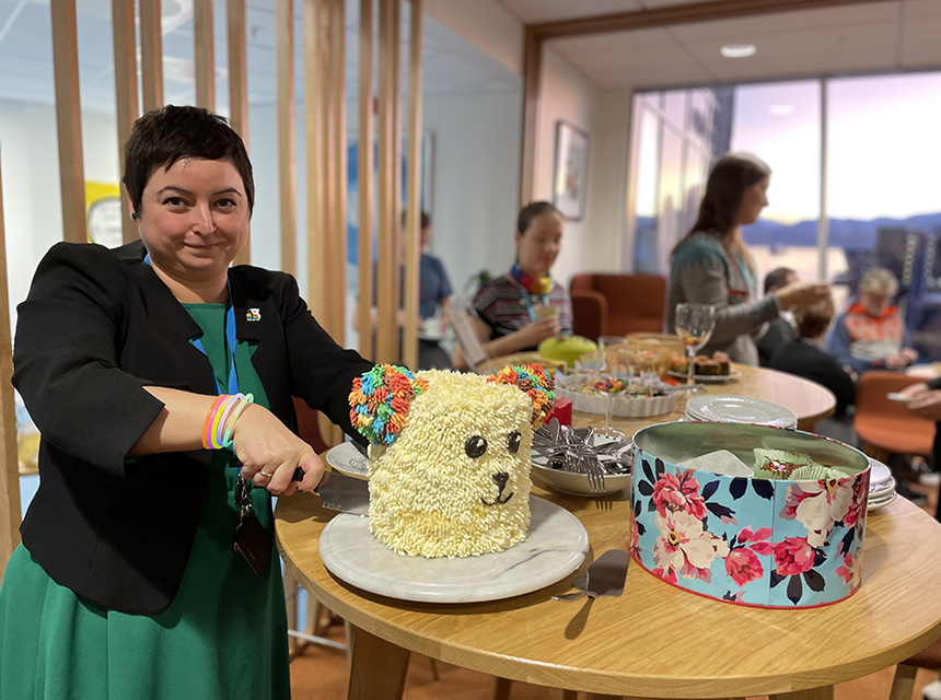 Kvinne skjærer i en kake formet som en isbjørn med fargerike ører