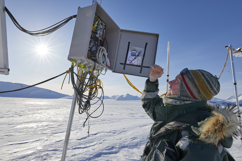 Mann sjekker instrument som er montert på en påle