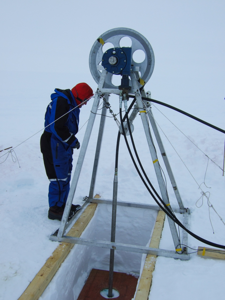 En person står ved siden av et instrument på isen