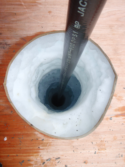 Et hull i isen med en vaier som går ned i hullet